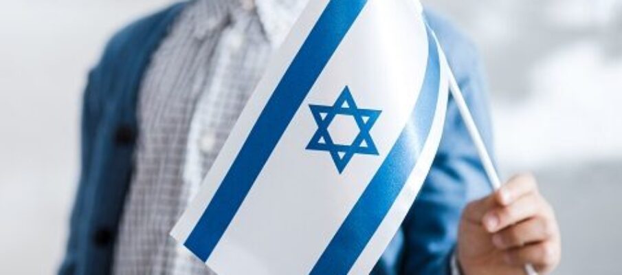 cropped view of smiling jewish boy holding flag of israel